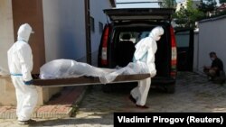 Медработники транспортируют тело умершей от COVID-19 женщины. Бишкек, 6 июля 2020 г.