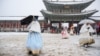 Hagyományos koreai öltözéket, <em>hanbok</em>ot viselő látogatók a szöuli Gyjongbokkung-palota területén 2024. november 27-én. Dél-Korea fővárosát november 27-én akkora hó borította be, amire száz éve nem volt példa