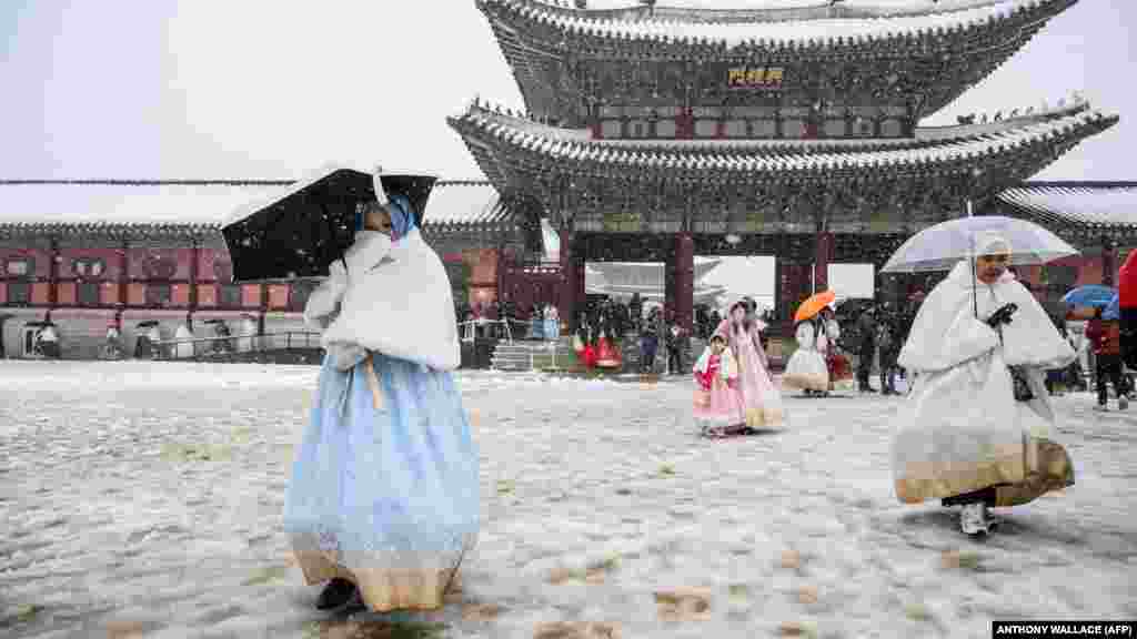 Hagyományos koreai öltözéket, hanbokot viselő látogatók a szöuli Gyjongbokkung-palota területén 2024. november 27-én. Dél-Korea fővárosát november 27-én akkora hó borította be, amire száz éve nem volt példa