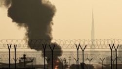 Панорама Дубая с культовым небоскребом Бурдж-Халифа на фоне столба дыма от продолжающегося пожара недалеко от международного аэропорта Дубая. 16 марта 2026 года