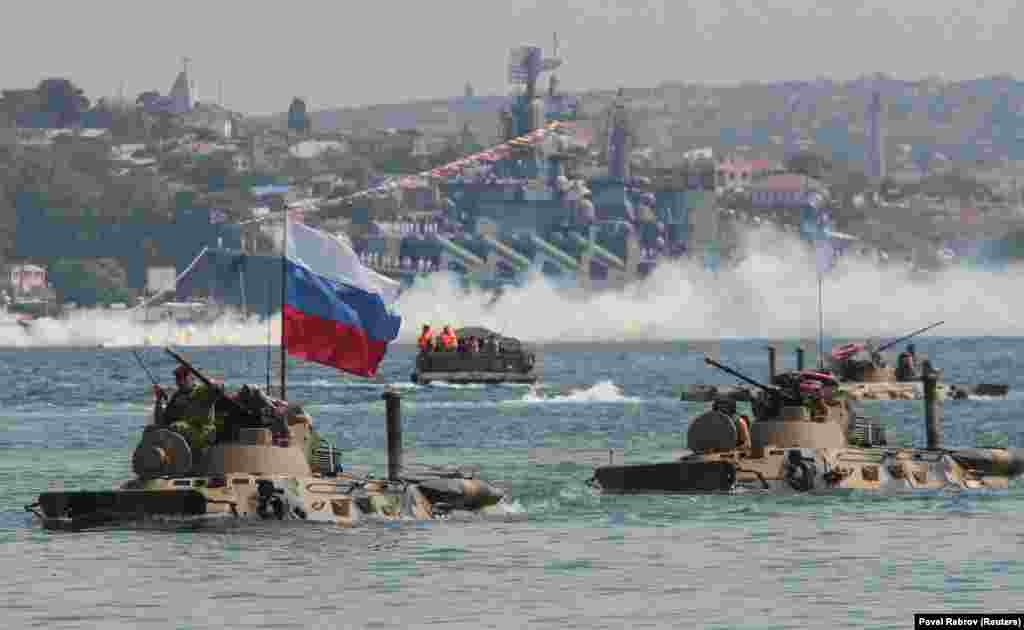 Amphibious vehicles drive in formation past the Russian missile cruiser Moskva during a rehearsal for the Navy Day parade in the Black Sea port of Sevastopol, Crimea. (Reuters/Pavel Rebrov)