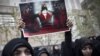 An Iranian student holds up a sign with a picture of a Bahraini protester in front of the Saudi Arabian Embassy in Tehran. Iran has been vocal in its criticism of Saudi actions against Shi'ite protesters in the Persian Gulf state.