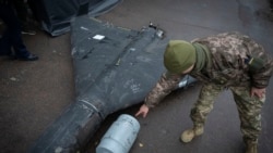 A Ukrainian officer points to a thermobaric charge from a downed Shahed drone launched by Russia from an undisclosed location in Ukraine.