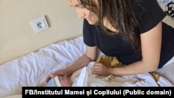 O femeie și nou-născutul ei la Institutul Mamei și Copilului.