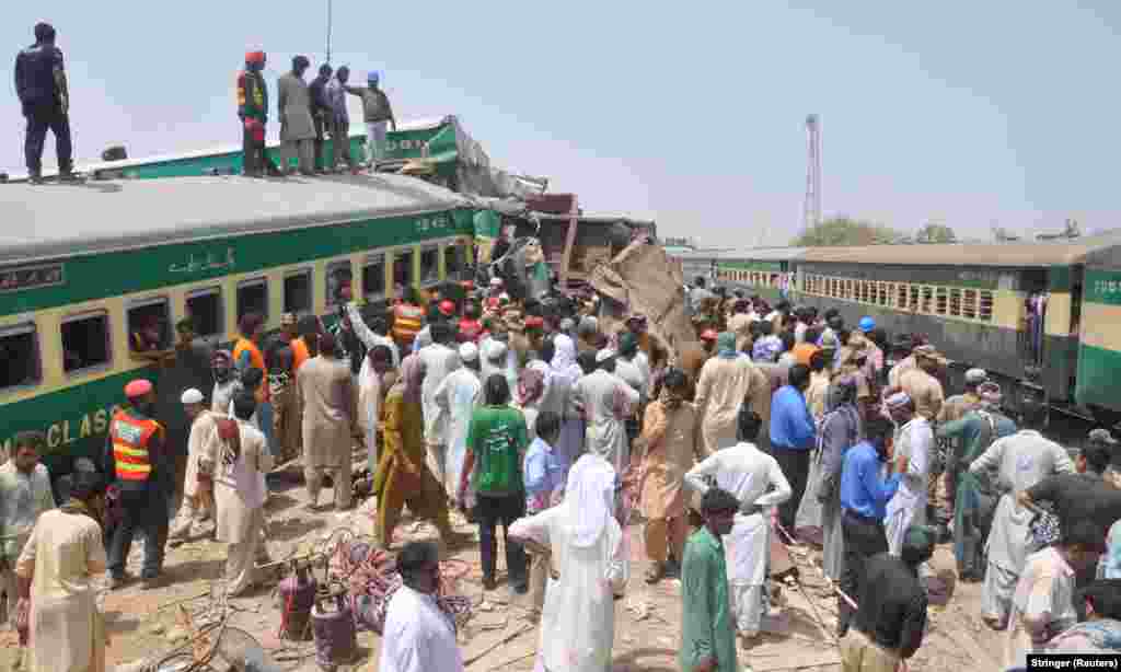Residents and rescue workers gather near the site after a passenger train collided with a cargo train in Sadiqabad, July 11, 2019