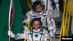 Japanese astronaut Koichi Wakata (top) and Russian cosmonaut Mikhail Tyurin, board the Soyuz TMA-11M spacecraft with the torch of the 2014 Sochi Winter Olympic Games at the Baikonur cosmodrome on November 7. 