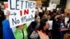 Demonstrators hold welcome signs for immigrants at San Francisco's international airport on January 28 as anger mounted over President Donald Trump's executive order. 