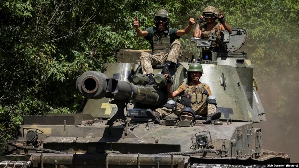 Ukrainian soldiers ride atop a self-propelled howitzer amid Russia's attack on Ukraine in the eastern Donetsk region on July 8.