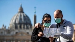 Туристи, одягнені у захисні маски, на Площі святого Петра у Ватикані, лютий 2020