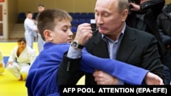 Владимир Путин, премьер-министр, показывает прием молодому спортсмену в центре дзюдо в комплексе «Арена» в сибирском городе Кемерове. 24 января 2012 года.