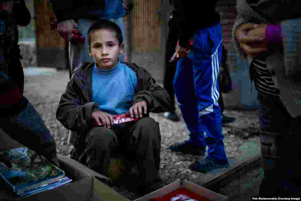 A young refugee boy unwraps chocolate distributed by volunteers in accommodation for displaced Ukrainians in&nbsp;Donetsk. Despite the truce between the separatists and Ukrainian&nbsp;government forces, there is still sporadic&nbsp;fighting.&nbsp;Refugees from shelled areas have sheltered inside Donetsk University campus buildings. 