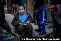 Un copil refugiat a primit o ciocolată.