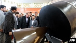 Iranian President Mahmud Ahmadinejad (far right, front) visits an exhibition of space technology during a ceremony to mark Iran's National Day of Space Technology in Tehran on February 4.