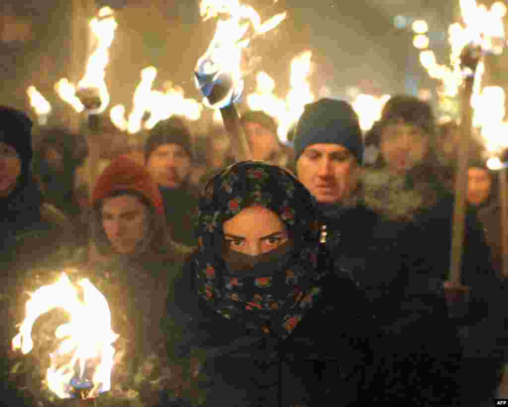 Marchers hold torches during a march in Lviv on January 1, 2016, as they mark the 107th anniversary of the birth of Stepan Bandera, a Ukrainian politician and one of the leaders of Ukrainian national movement in western Ukraine. (AFP/Yuriy Dyachyshyn)