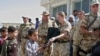 British and Romanian soldiers from the NATO-led force distribute school bags to Afghan children on the outskirts of Kabul.