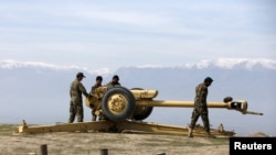 Afghan National Army (ANA) soldiers clean an artillery at the hilltop in Central Afghanistan.