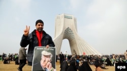 An Iranian man holds a poster with a cartoon of U.S. President Donald Trump during a ceremony to mark the 38th anniversary of the Islamic Revolution on Azadi Square in Tehran on February 10.