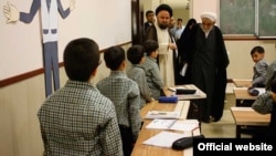 Two clerics visit a school in Tehran. (file photo)