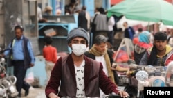 Мужчина в маске на мотоцикле в столице охваченного войной Йемена. Сана, 16 марта 2020 года.