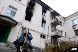 An elderly man sits in front of a building destroyed during combat and shelling between Ukrainian forces and pro-Russian militants in the eastern city of Donetsk on November 13.