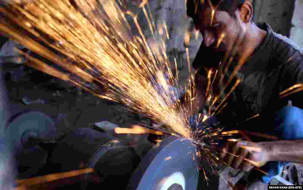 A blacksmith sharpens knives ahead of the Muslim festival of Eid al-Adha in Karachi, Pakistan.&nbsp;