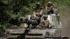 Ukrainian soldiers ride atop a self-propelled howitzer amid Russia's attack on Ukraine in the eastern Donetsk region on July 8.