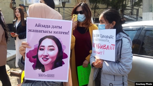 Demonstrators in Osh hold up pictures of 27-year-old Aizada Kanatbekova, who was abducted and found dead.