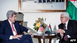 U.S. Secretary of State John Kerry (left) and Palestinian Authority President Mahmud Abbas talk before a meeting at the presidential compound in the West Bank city of Ramallah on January 3.