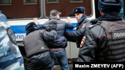 Полиция обыскивает одного из задержанных на Манежной площади