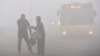 A bus moves along a street as thick smoke from Yakutia wildfires hangs over the northern city of Norilsk on August 6. 