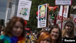 People carry posters denouncing Russia's policies on homosexuality at a parade in Berlin on June 22.