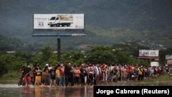 Ljudi na poplavljenoj ulici tokom prolaska Oluje Eta, u Pimienti, Honduras