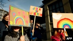 Copiii țin pancarte în culorile curcubeului, la Hamburg, la 28 ianuarie, la un protest împotriva excluziunii și extremei-drepte, sub genericul „Toți sunt bineveniți”. În Rusia, părinții ar fi chemați, probabil, să dea socoteală. 