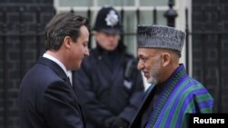 د برتانیا لومړی وزیر ډیویډ کېمرن د افغانستان ولسمشر حامد کرزی ته په ټډواننیګ سټریت کې د هغه د ورتلو پرمهال هرکلی وايي.مارچ لومړۍ نېټه ۲۰۱۱م کال