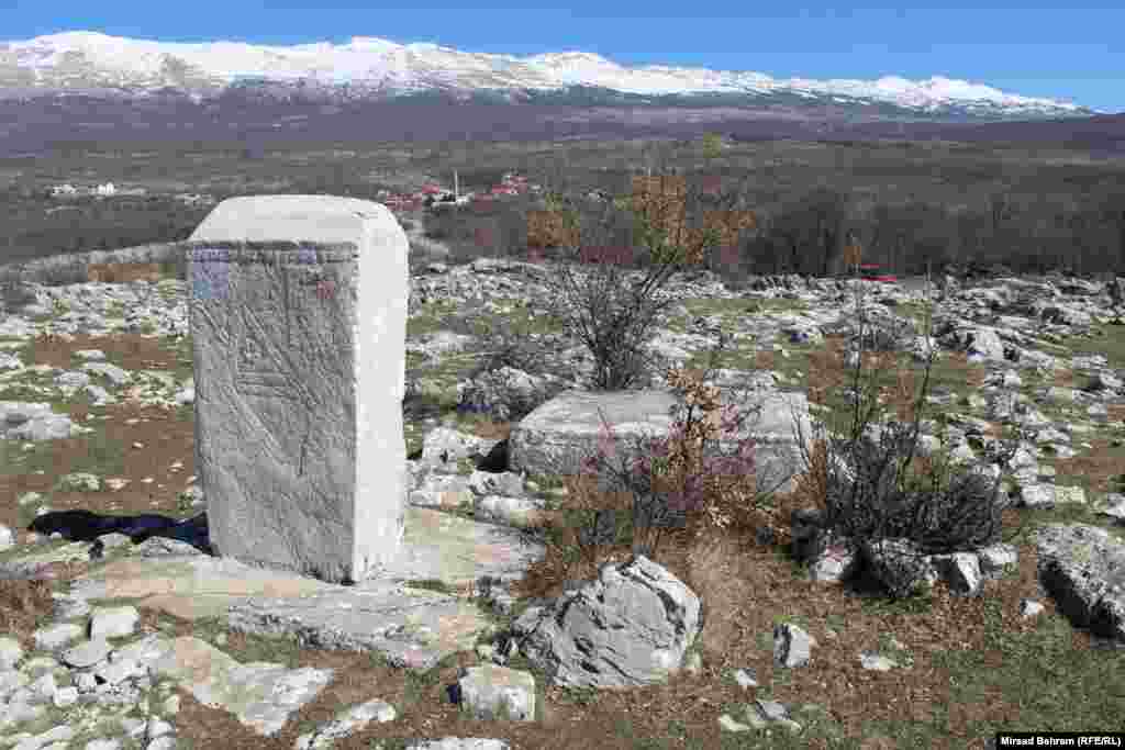 Reljefima ukrašeni stećak u nekropoli na lokalitetu Humčica; u pozadini se vidi selo Podvelež, pored kojeg se nalazi jedna od dvije nekropole.