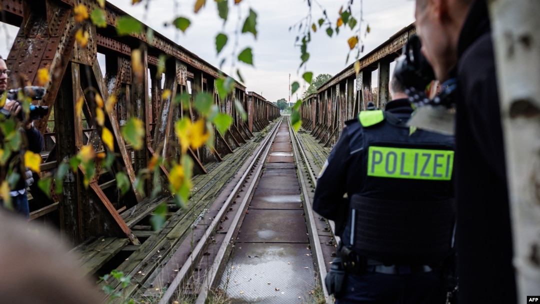 Ofițerii de poliție federală stau lângă o rută frecvent utilizată de migranți la granița germano-polonă, lângă Forst, în estul Germaniei.