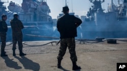 Russian security personnel in Sevastopol stand guard during the seizure of Ukrainian warships after the Kremlin illegally occupied Crimea in 2014. 