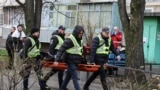 Рятувальники несуть тіло людини, загиблої унаслідок нової масованої атаки РФ на Київ, 14 листопада 2025 року