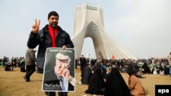 An Iranian man holds a poster with a cartoon of U.S. President Donald Trump during a ceremony to mark the 38th anniversary of the Islamic Revolution on Azadi Square in Tehran on February 10.