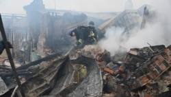 Ukrainian emergency workers extinguish a fire at a house after a drone strike in Kharkiv on December 25. 