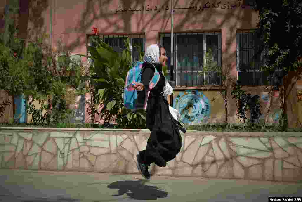 A young Afghan student jumps over her skipping rope outside a school in Herat on September 20.&nbsp;