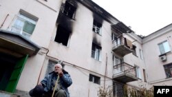 Ukraine -- An elderly man sits in front building destroyed during combat and shelling between Ukrainian forces and pro-Russian militants in eastern city of Donetsk, 13, 2014