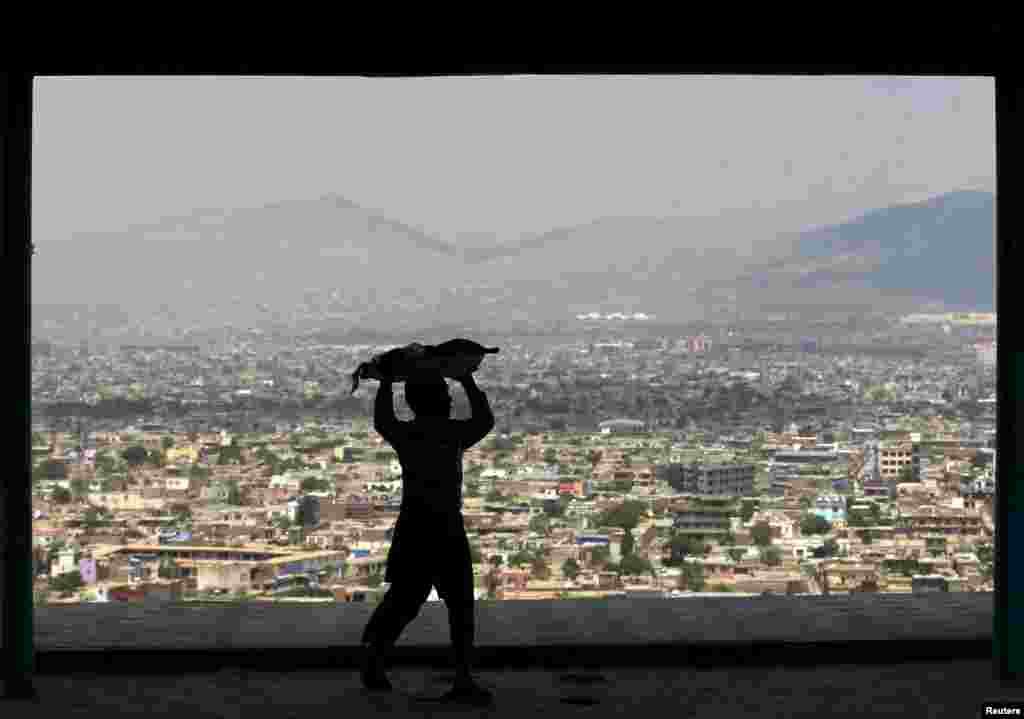 A boy carries bread to sell on a hilltop overlooking Kabul. (Reuters/Mohammad Ismail)