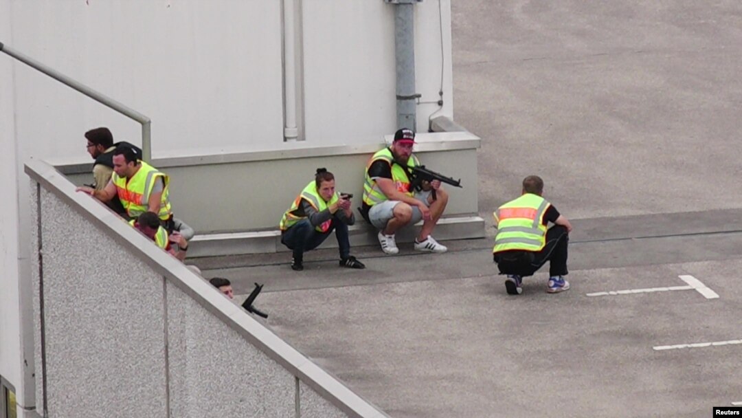 A screen grab taken from video footage shows plain clothes police officers taking cover in the car park of the Olympia shopping mall.
