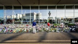 The Netherlands -- A sympathizer stands in front of a sea of flowers left in memory of the victims of Malaysian Airlines flight MH17, at Schiphol Airport, near Amsterdam, The Netherlands, July 31, 2014. 