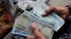 FILE: An Afghan currency exchange dealer waits for customers at a roadside in the southern Afghan city of Kandahar