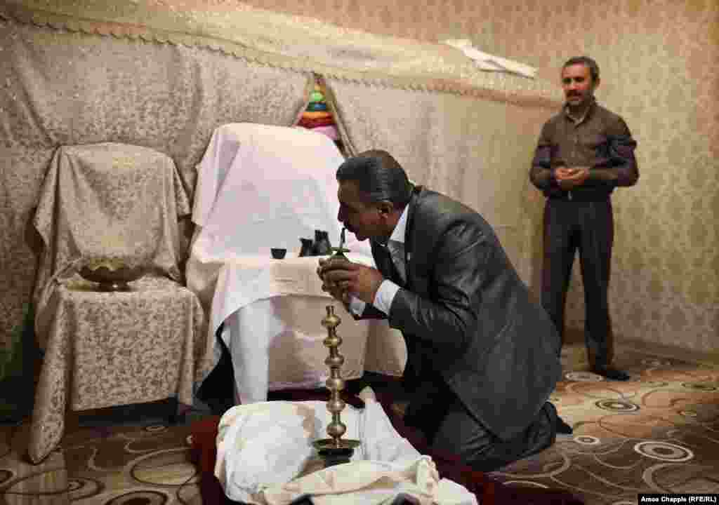 Sheikh Aziz, a senior spiritual leader for Armenian Yazidis, kisses a tiny brass peacock in deference to Melek Taus, the Peacock Angel, which is the central figure in the Yazidi faith.