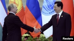 Chinese President Hu Jintao (right) greets his Russian counterpart Vladimir Putin in Beijing