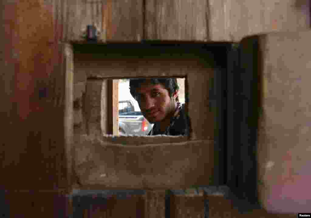 A security guard looks out from a viewing panel at the Sufi Restaurant in Kabul on January 20. (Reuters/Omar Sobhani)