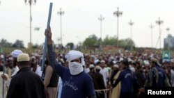 FILE: A man holds a stick while taking part in a sit in protest against the execution of Mumtaz Qadri outside the Parliament building in Islamabad, Pakistan in March 2016.